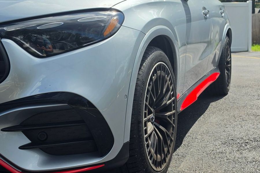 Front three-quarter view of the AMG GLC 53 showing the red side skirt accent
