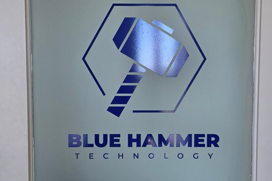 Frosted glass door with the Blue Hammer Technology logo applied in vinyl