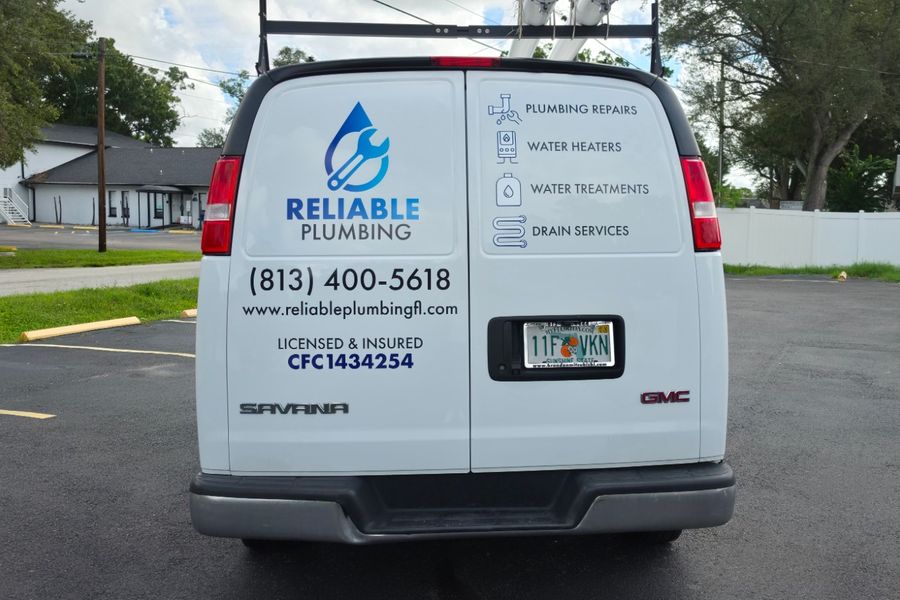 Rear doors of the plumbing van with a service list, phone number and license number