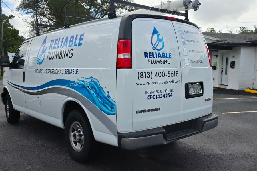Rear three-quarter view of the plumbing van showing how the graphics wrap around the body
