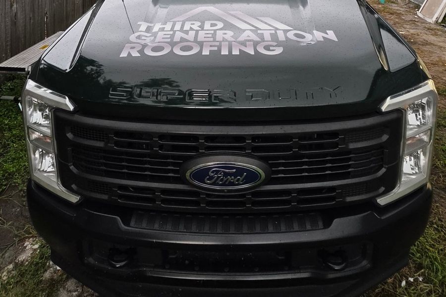 Front of the Ford F-350 with hood graphics over a dark green wrap