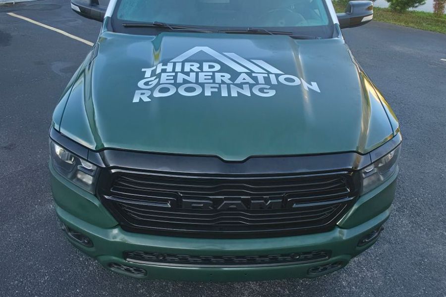 Hood of the RAM 1500 with the roofing company logo applied in white vinyl