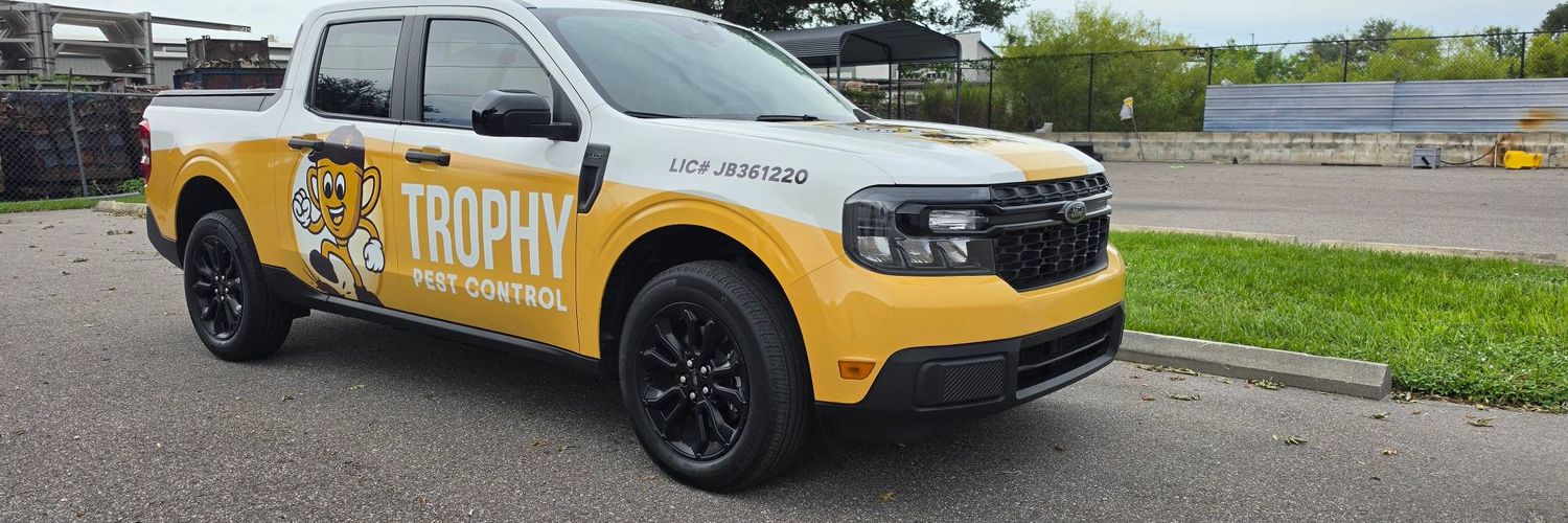 Front three-quarter view of the Trophy Pest Control truck showing the full mascot design