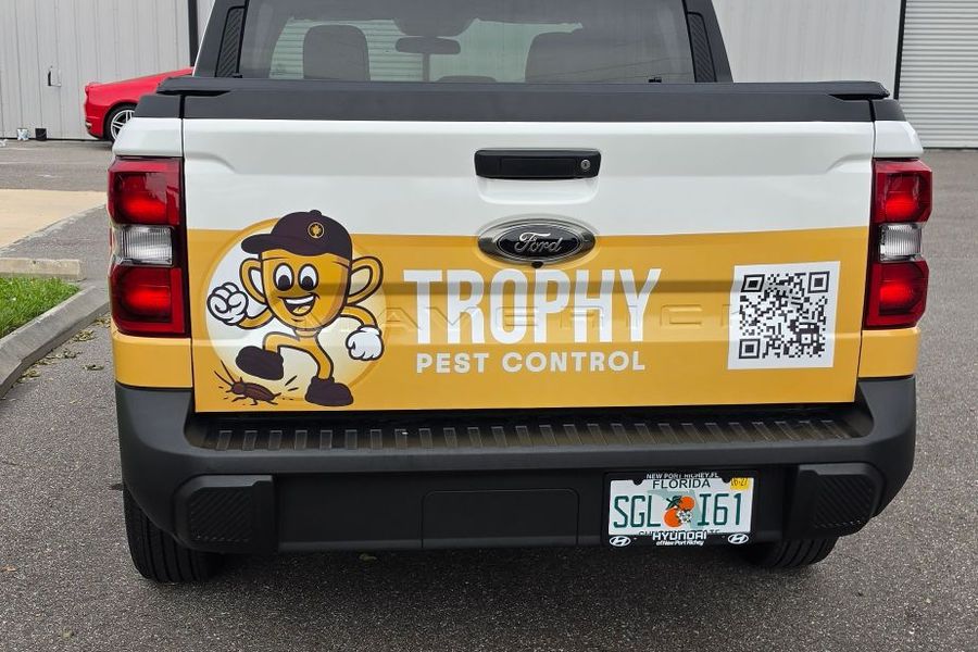 Tailgate of the pest control truck with the mascot, company name and a scannable QR code